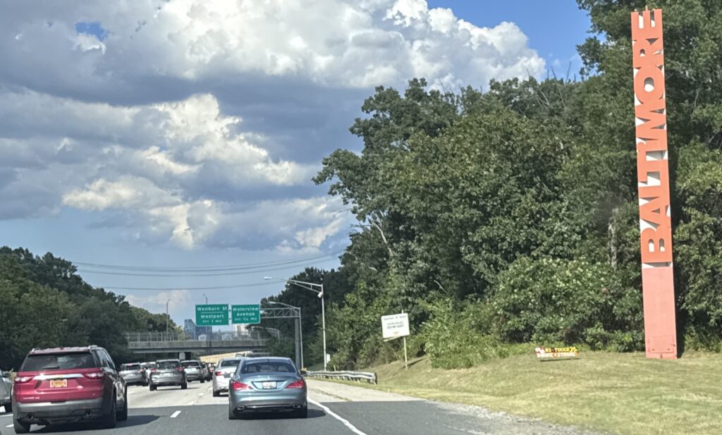 A photo of a busy highway in Baltimore&rsquo;s Port Covington 21230 neighborhood, showing heavy traffic on a sunny day.